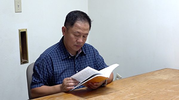 刘晓斌在阅读《转法轮》。（刘晓斌提供）