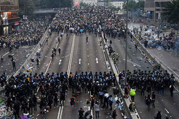 - Protesters face off with police after they fired tear gas during a rally against a controversial extradition law proposal outside the government headquarters in Hong Kong on June 12, 2019. - Violent clashes broke out in Hong Kong on June 12 as police tried to stop protesters storming the city's parliament, while tens of thousands of people blocked key arteries in a show of strength against government plans to allow extraditions to China. (Photo by Anthony WALLACE / AFP) (Photo credit should read ANTHONY WALLACE/AFP/Getty Images)
