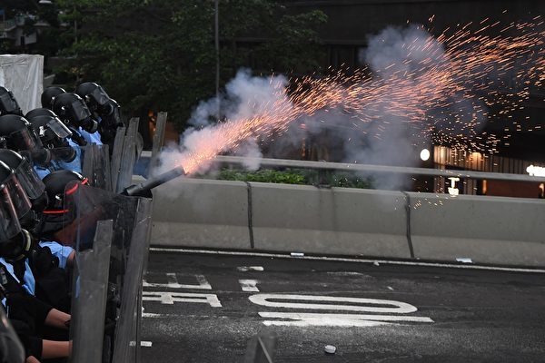 A policeman fires a tear gas shell during a rally against a controversial extradition law proposal outside the government headquarters in Hong Kong on June 12, 2019. - Violent clashes broke out in Hong Kong on June 12 as police tried to stop protesters storming the city's parliament, while tens of thousands of people blocked key arteries in a show of strength against government plans to allow extraditions to China. (Photo by Anthony WALLACE / AFP) (Photo credit should read