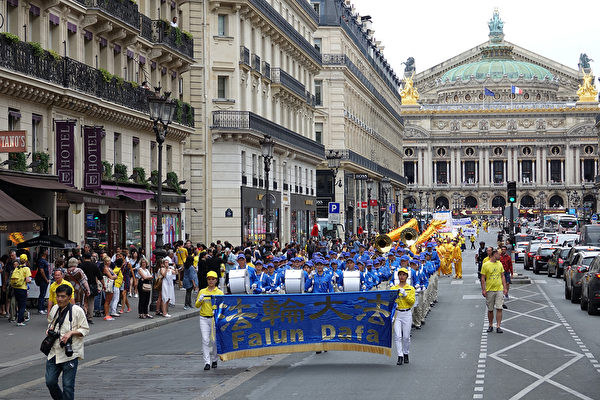 7月20日下午，来自欧洲十几个国家的部分法轮功学员在法国巴黎举行“纪念法轮功学员反迫害20周年”大游行，图为游行队伍途经巴黎歌剧院。（叶萧斌/大纪元）