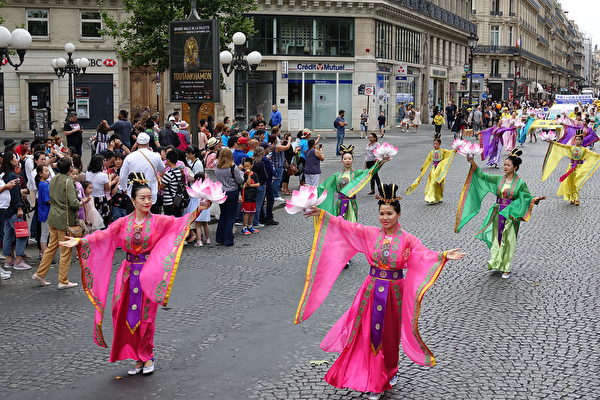 7月20日下午，来自欧洲十几个国家的部分法轮功学员在法国巴黎举行“纪念法轮功学员反迫害20周年”大游行。沿途许多民众，包括大陆游客围观拍照。（叶萧斌/大纪元）