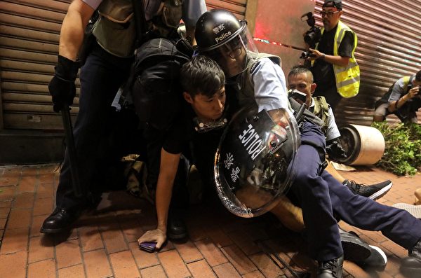 A protester is being hold on the floor by the police during a clash between protesters and police in the Mong Kok district in Kowloon after taking part in a march to the West Kowloon rail terminus against the proposed extradition bill in Hong Kong on July 7, 2019. - Tens of thousands of anti-government protesters rallied outside a controversial train station linking the territory to the Chinese mainland on July 7, the latest mass show of anger as activists try to keep pressure on the city's pro-Beijing leaders. (Photo by VIVEK PRAKASH / AFP)