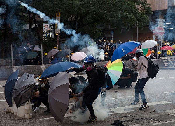 黃大仙處警方持續施放多枚催淚彈。示威者用雨傘遮擋。（ISAAC LAWRENCE/AFP/Getty Images)