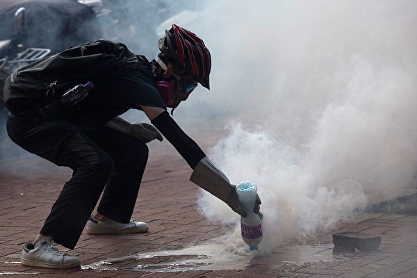 黄大仙警察发射催泪弹后，示威者用水浇灭催泪烟。（ISAAC LAWRENCE/AFP/Getty Images)