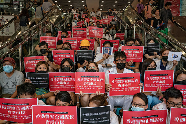 8月13日，大批港人繼續在機場抗議港警8.11施暴，手舉標語。