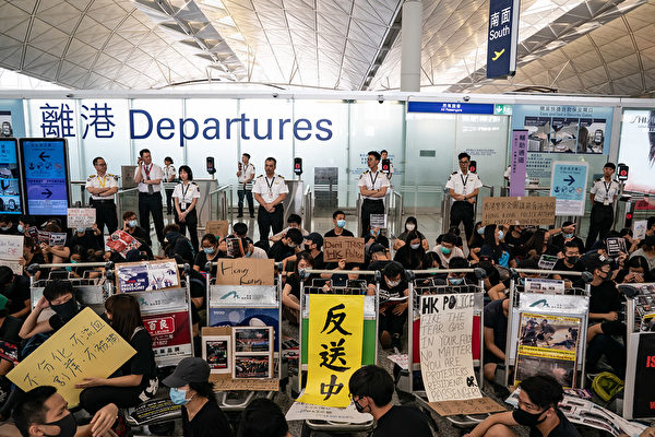 8月13日，大批港人繼續在機場抗議港警8.11施暴，手舉標語。
