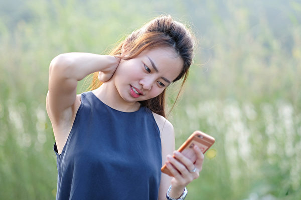 经常滑手机容易造成颈部僵硬疲劳，引起“简讯颈”症状。(Shutterstock)