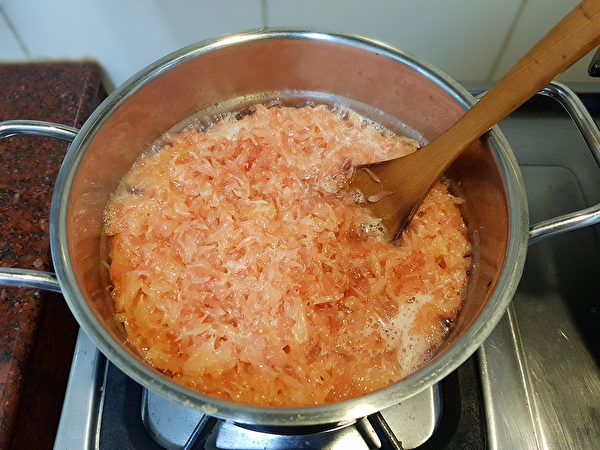 一边熬煮柚子，一边以木匙慢慢搅拌，避免黏锅。（苏冠米／大纪元）