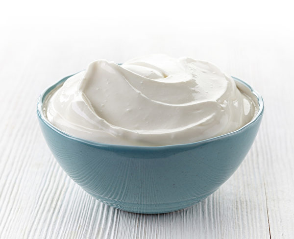 bowl of sour cream on white wooden table