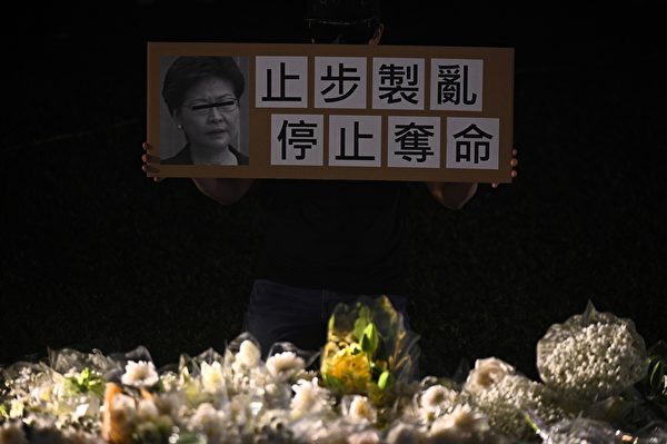 11月9日，港人舉行「『主佑義士』全港祈禱及追思會」悼念周梓樂。圖為參與者舉著要求特首林鄭月娥止步製亂、停止奪命的牌子。（PHILIP FONG/AFP via Getty Images）
