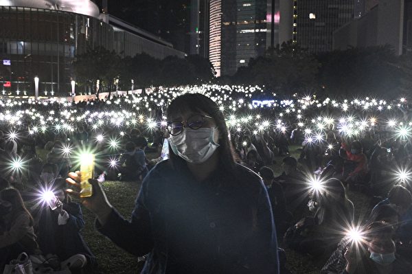 2019年11月9日，香港民众在金钟添马公园举行“主佑义士”全港祈祷及追思会。民众举起手机，并打开自带灯，现场一片光海。（HILIP FONG/AFP via Getty Images）