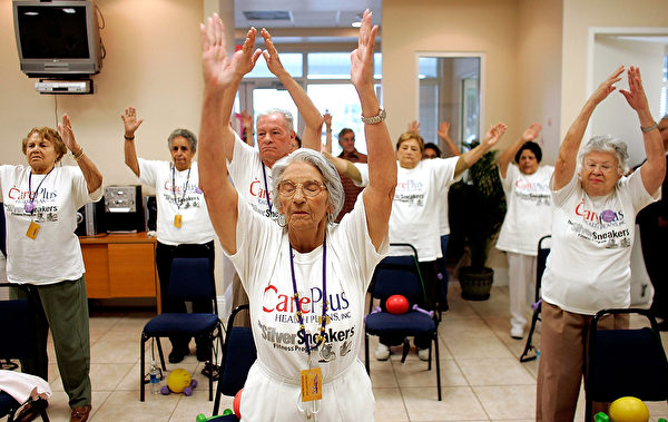 MIAMI - MARCH 22: Concepcion Cartaya (C) stretches as she listens to an exercise instructor lead their class during a work out at the CAC-Florida medical center March 22, 2007 in Miami, Florida. The center, formerly the Clinica Asociacion Cubana and now owned by Humana, provides seniors with regular primary care physicians and access to specialists several times a week. The center, emphasizing its Cuban approach, provides a place not only where health care is provided, but a kind of meeting place for the community where patients can be found playing card games, exercising, enjoying refreshments and participating in bingo tournaments and other events. (Photo by Joe Raedle/Getty Images)