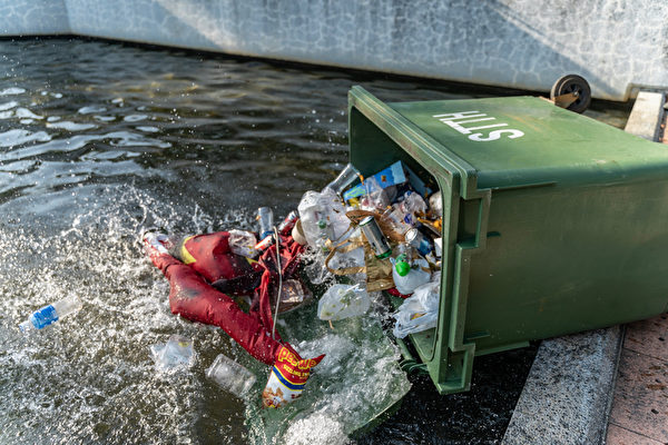 9月22日，民众把中共血旗扔进垃圾桶并推入水池。（Anthony Kwan/Getty Images）