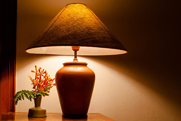 Vintage table lamp light on wooden table with flowers .Fotolia