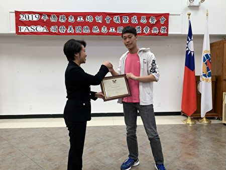 經文處處長頒獎給總統志工服務金獎的李鈞彥。