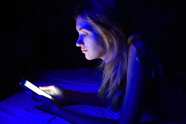 young women using the smart phone on bed before sleep.（shutterstock）
