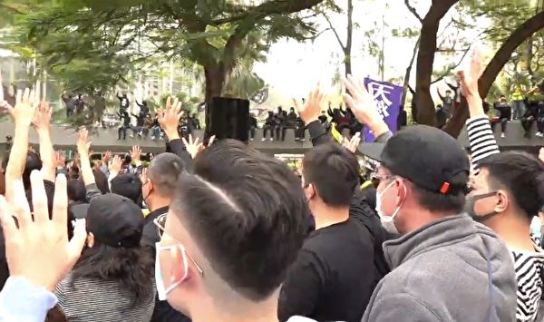 1月19日，港人舉行流水式集會，現場齊唱《願榮光歸香港》，並伸出五手指，表示五大訴求。（大紀元視頻截圖）
