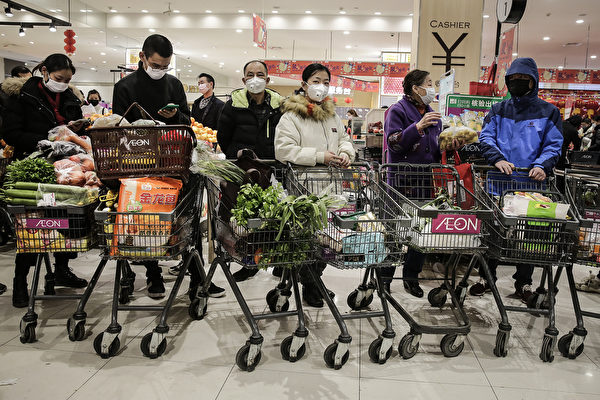 武汉市民戴口罩排队到超市买菜。（Photo by Getty Images）