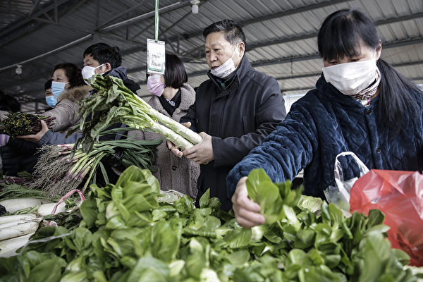 武汉市民戴口罩排队到超市买菜。（Photo by Getty Images）