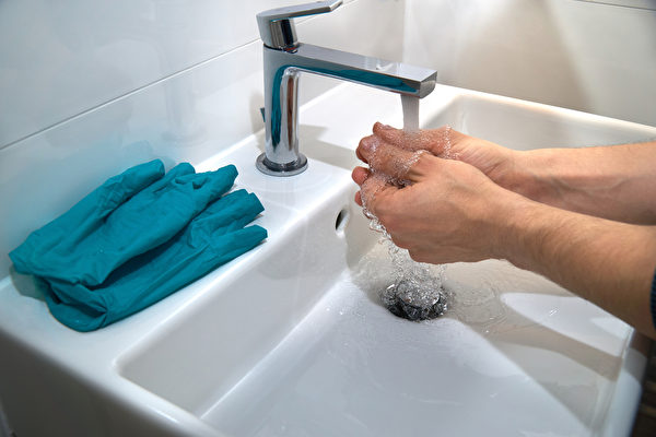 脱手套時，應從內向外翻脱，避免病毒碰處皮膚。戴前脱後都要洗手。(Shutterstock)