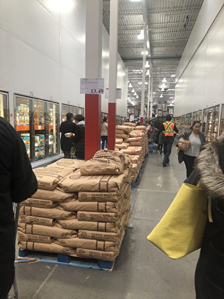 圖：溫哥華各地突顯搶購風，一些民眾擔憂新冠肺炎擴大，圖為商家將米麵擺放在走道上。（邱晨／大紀元）