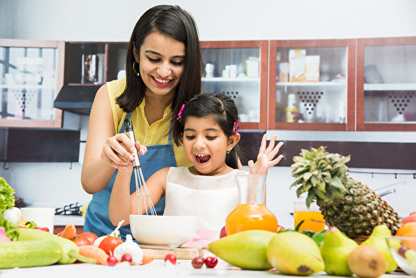Mother and daughter cook together. (Shutterstock)