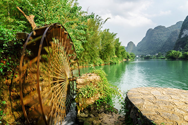 Moving water wheel (noria) on the Yulong River, Guilin, China Moving water wheel (noria) on the Yulong River, Guilin, China