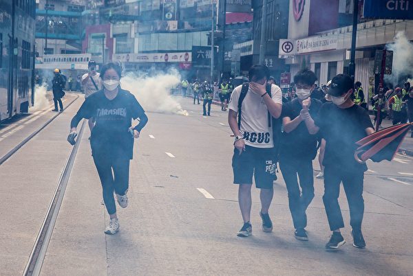 2020年5月24日，香港反國安法遊行。防暴警察施放催淚彈，市民避走。（ ISAAC LAWRENCE/AFP via Getty Images）