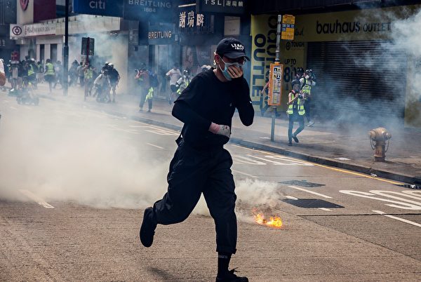2020年5月24日，香港反国安法游行。防暴警察施放催泪弹，市民避走。（ ISAAC LAWRENCE/AFP via Getty Images）