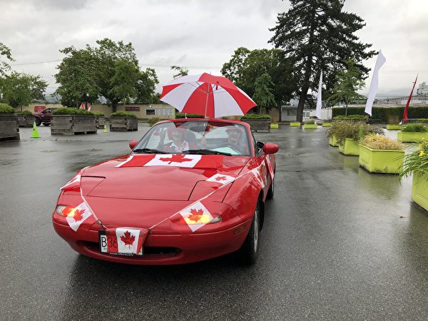 图：PNE举办加拿大国庆日汽车游行，雨中体验别样的节日喜庆。图为Karoline夫妇。（邱晨/大纪元）