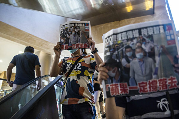 8月11日，港人在商场中，举着《苹果日报》表示抗议。（ISAAC LAWRENCE/AFP via Getty Images）