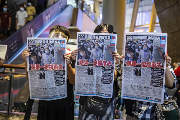8月11日，港人在商場中，舉著《蘋果日報》表示抗議。（ISAAC LAWRENCE/AFP via Getty Images）