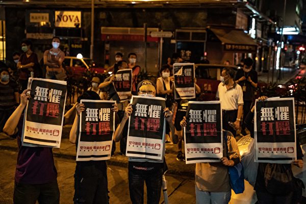 8月12日凌晨，港人在旺角警署等候黎智英獲釋，高舉《蘋果日報》以示抗議。（Anthony Kwan/Getty Images）