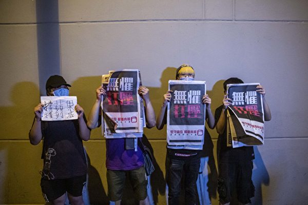 8月12日凌晨，港人在旺角警署等候黎智英获释，高举《苹果日报》以示抗议。（ISAAC LAWRENCE/AFP via Getty Images）