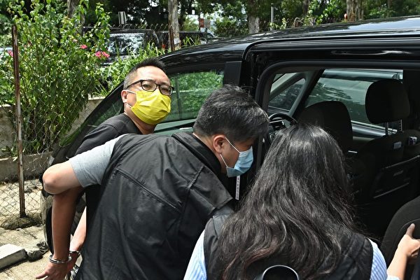 9月6日，香港民主派政黨「人民力量」副主席譚得志（圖中黃色口罩者）被多名便衣警察撬門闖入後拘捕。（宋碧龍/大紀元）
