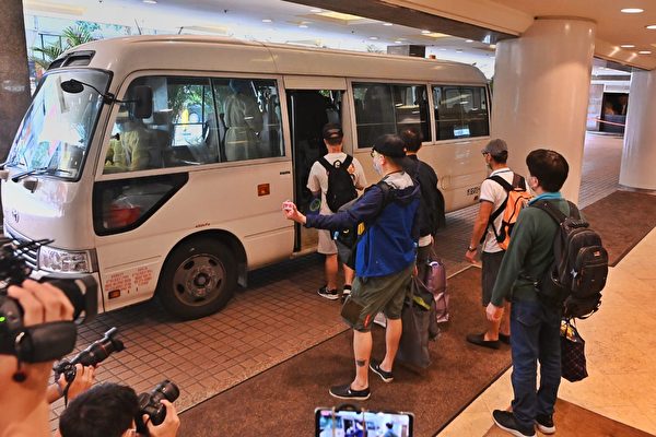 香港五星級酒店帝苑酒店（The Royal Garden）因有員工染疫，近100名職員要接受檢疫隔離。圖為酒店員工走出酒店後被送往隔離地點。（宋碧龍/大紀元）