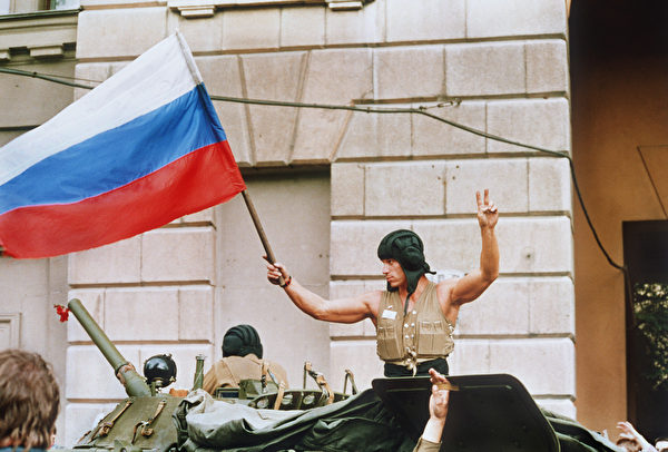 1991年8月21日，對戈爾巴喬夫總統發動軍事政變失敗後，裝甲部隊從莫斯科撤離，一名士兵從坦克頂部揮舞著俄羅斯國旗。（WILLY SLINGERLA