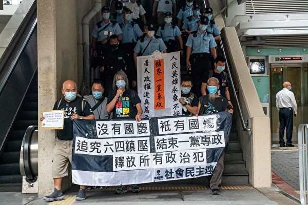 10月1日，香港支聯會及社民連等團體到中聯辦外抗議，並要求釋放12名港人。警察緊跟其後。（Anthony Kwan/Getty Images）