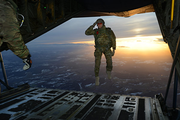 2015年2月24日，在德国空降区演习中，美军第10特种兵小组第1营的一名美军士兵跳出C-130大力神运输机时向同伴敬礼。（美国陆军）