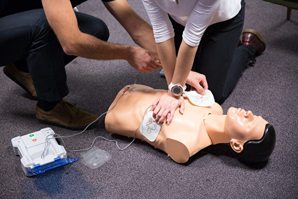 在使用自动体外心脏去颤器（AED）急救时，听到语音警示前不要停止CPR。(Shutterstock)