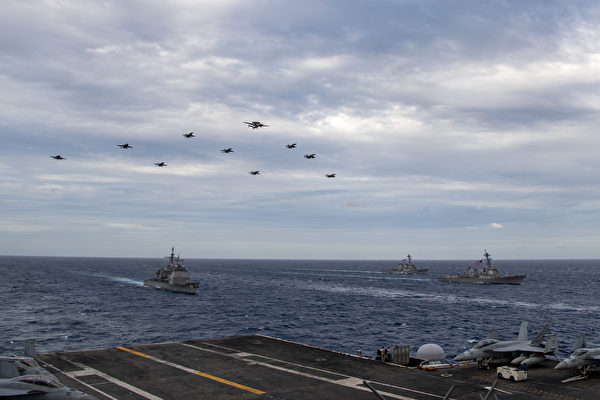2月9日，美军双航母在南海演练，舰载机编队飞跃舰队上空。（美国海军）
