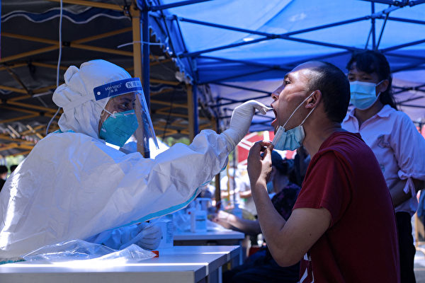 广州市本轮疫情持续发酵，广州全市核酸大排查中又发现阳性病例。图为5月30日，广州市民做核酸检测。（STR/AFP via Getty Images）