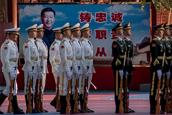2020年10月22日，中共準備紀念朝鮮戰爭前夕，中共儀仗隊士兵在北京紫禁城外的習近平畫像旁。中共軍隊僅聽命於中共最高領導人。（Nicolas Asfouri/AFP via Getty Images）