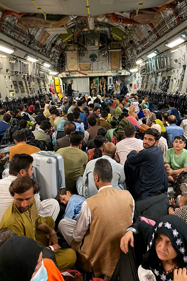 8月19日，一些阿富汗人登上一架美國軍用飛機內離開阿富汗。（Shakib Rahmani/AFP via Getty Images）