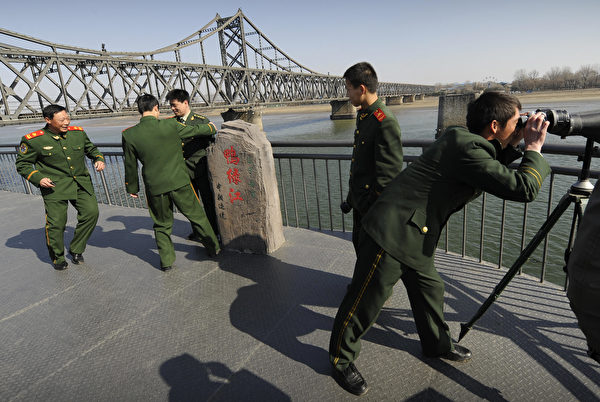 2009年3月23日，中共军队士兵参观连接朝鲜的鸭绿江大桥。（Peter Parks/AFP via Getty Images）