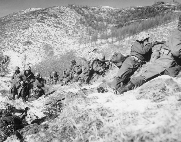 1950年12月6日，美国海军陆战队员在朝鲜战场大雪覆盖的山中战斗。（Hulton Archive/Getty Images）