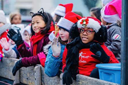 往年河源镇圣诞篝火游行途中，观看游行的孩子们向游行队伍挥手。
