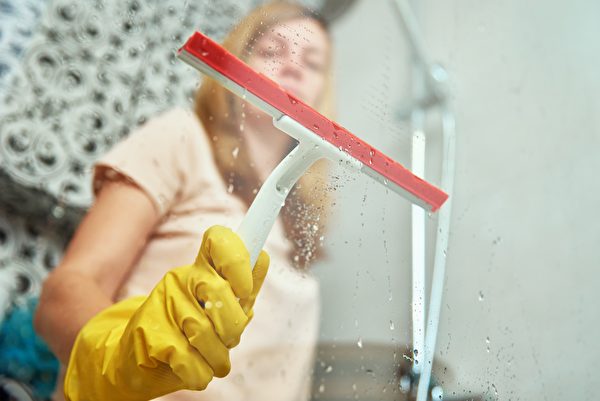 清洁玻璃门窗时，可用刮刀刮除水痕。(Shutterstock)