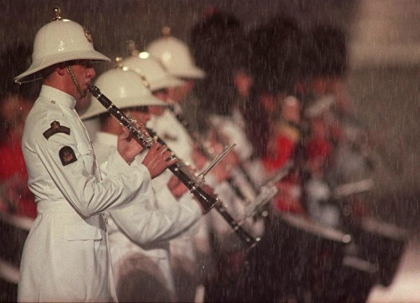 1997年6月30日夜，英國海軍陸戰隊樂隊成員在傾盆大雨中吹奏，當晚英國政府向中共移交香港主權，結束了在香港的殖民地治理。（Manny Ceneta/AFP via Getty Images）