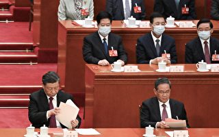 2023年3月10日，中共两会上，习近平（左）、李强（右）坐在主席台上翻看文件。（NOEL CELIS/AFP via Getty Images）